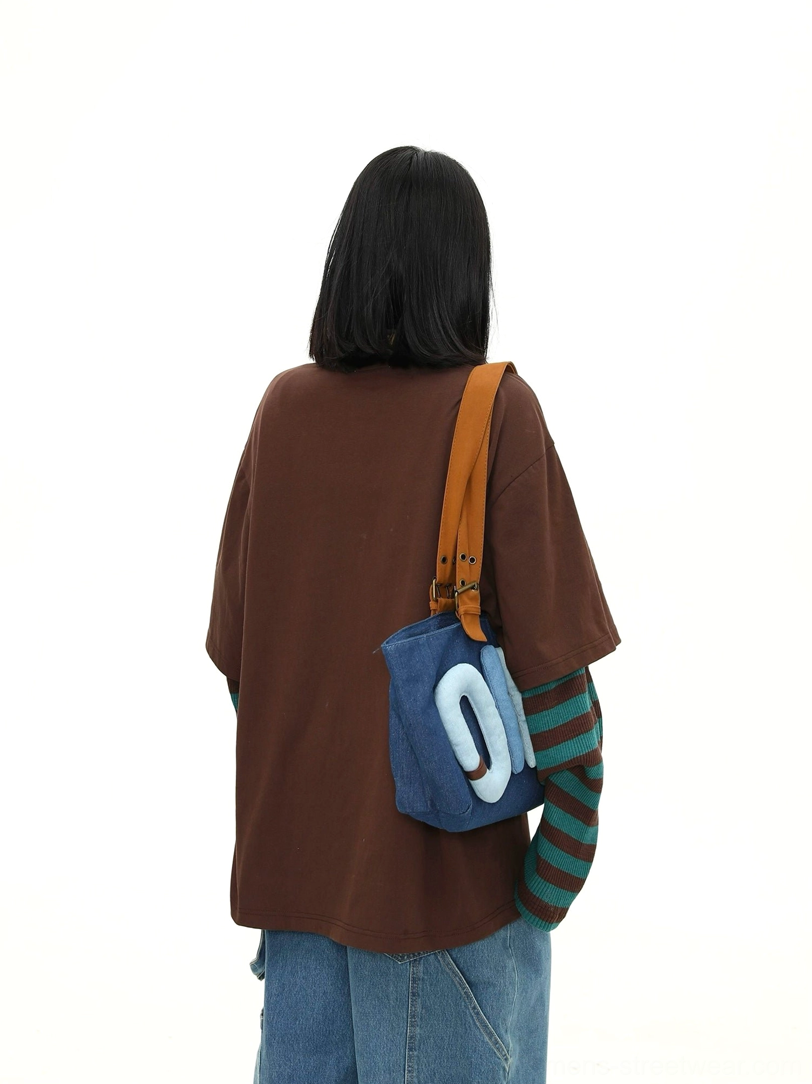 Back view of an oversized solid brown streetwear T-shirt with striped long sleeves visible from the rear