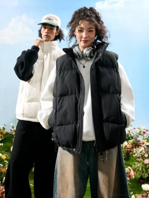 Unisex oversized black and white stand collar puffer vests styled with layered streetwear outfits outdoors