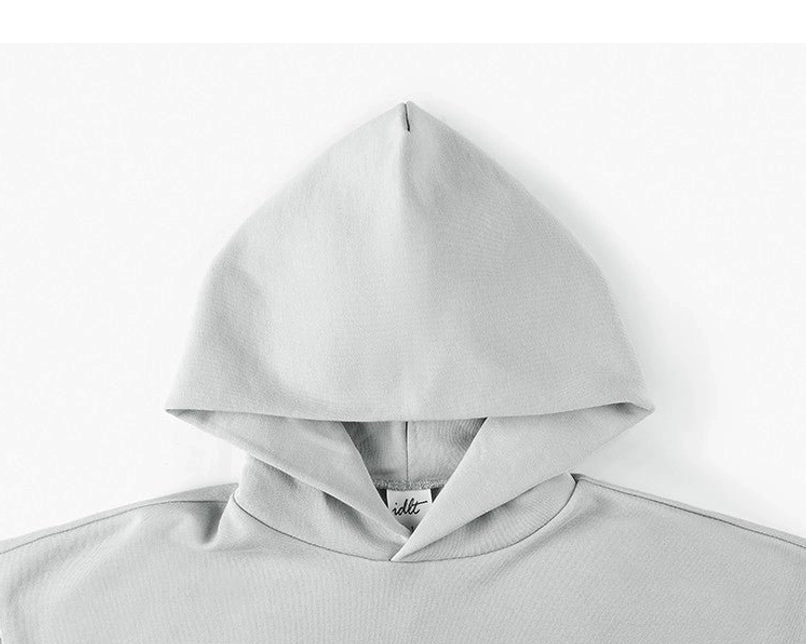 Close-up of oversized streetwear hoodie neckline showing soft gray hood fabric inner tag and neat stitching