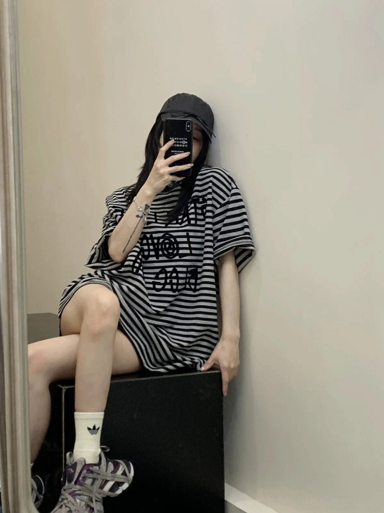 Side-back view of an oversized striped graphic T-shirt with rolled short sleeves, loose boxy fit, and casual Korean streetwear styling