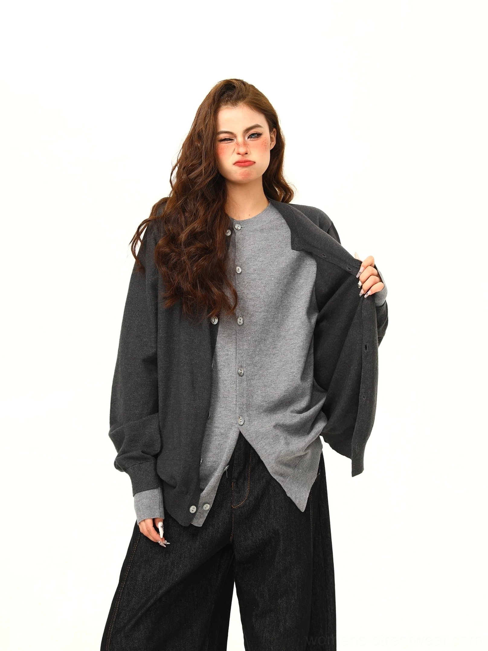 Three-quarter view of a women’s oversized two-tone gray cardigan showing the dark outer layer and light gray inner panel