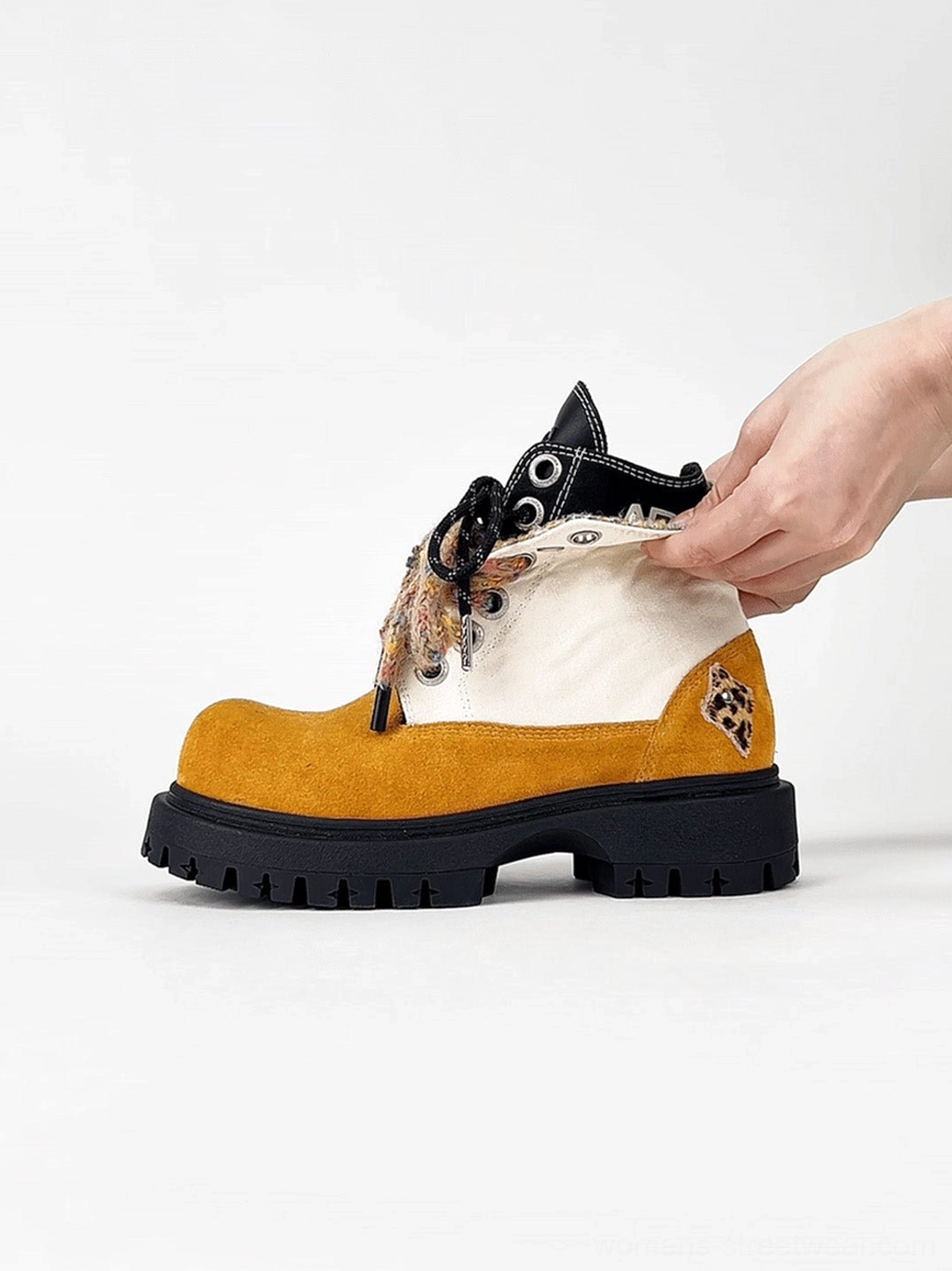 Close-up of oversized two-tone suede-look work boot with adjustable fuzzy collar trim and detailed lace system