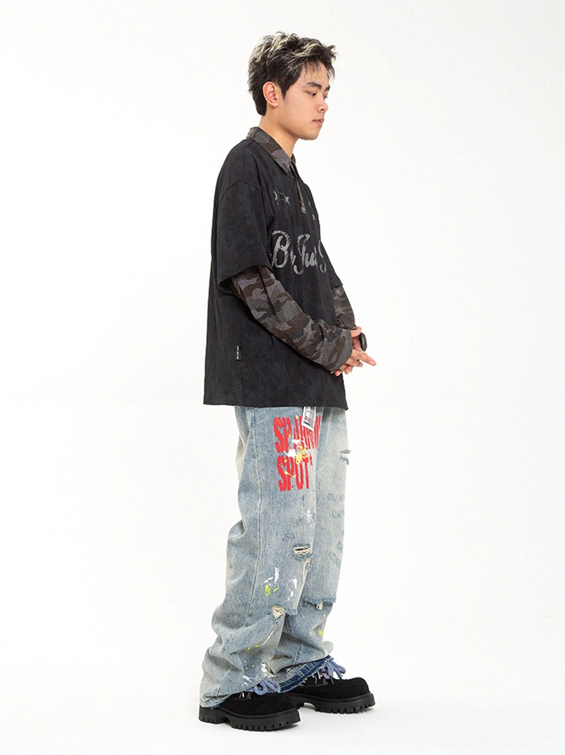 Male model wearing oversized two-tone suede-look work boots with distressed printed jeans and graphic long-sleeve shirt