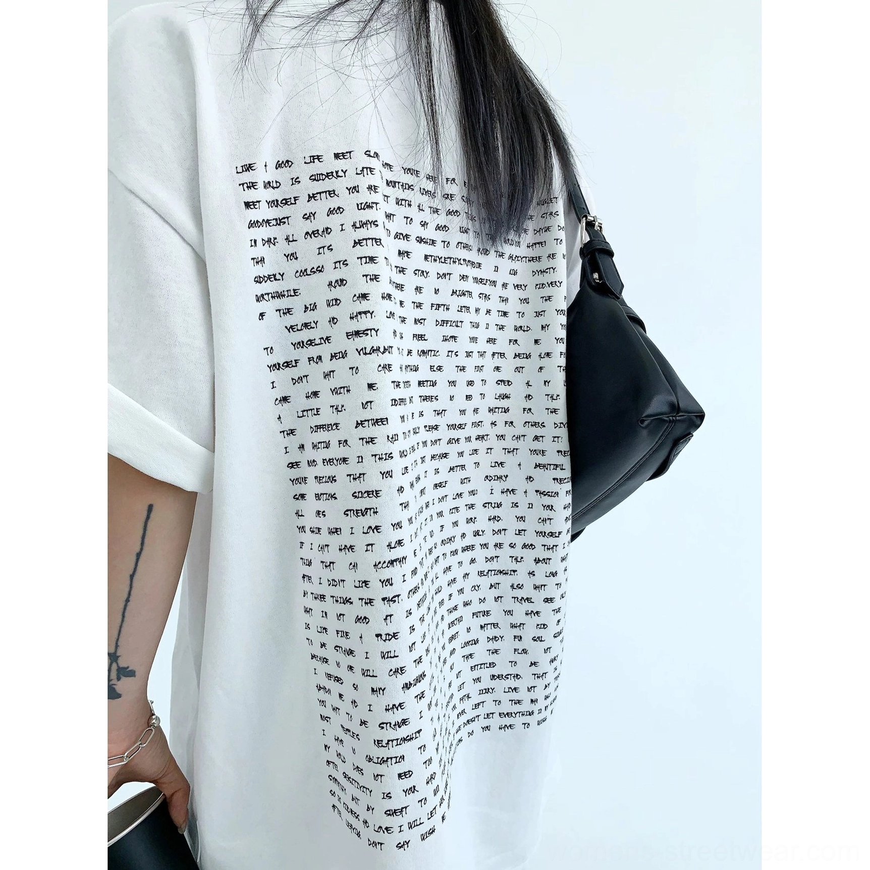 Close-up of white oversized typography back print streetwear T-shirt showing dense English text graphic and cotton texture