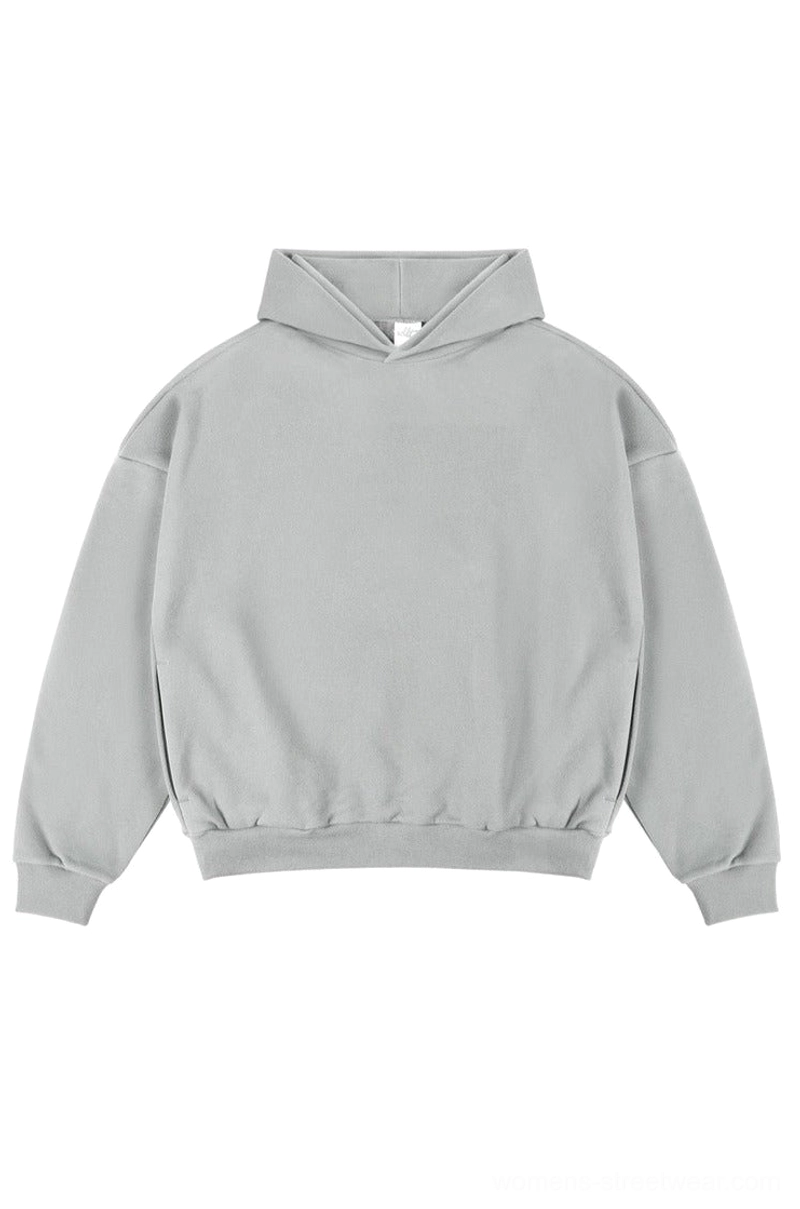 Light heather gray oversized unisex streetwear hoodie with dropped shoulders ribbed cuffs and classic hood on a white studio background