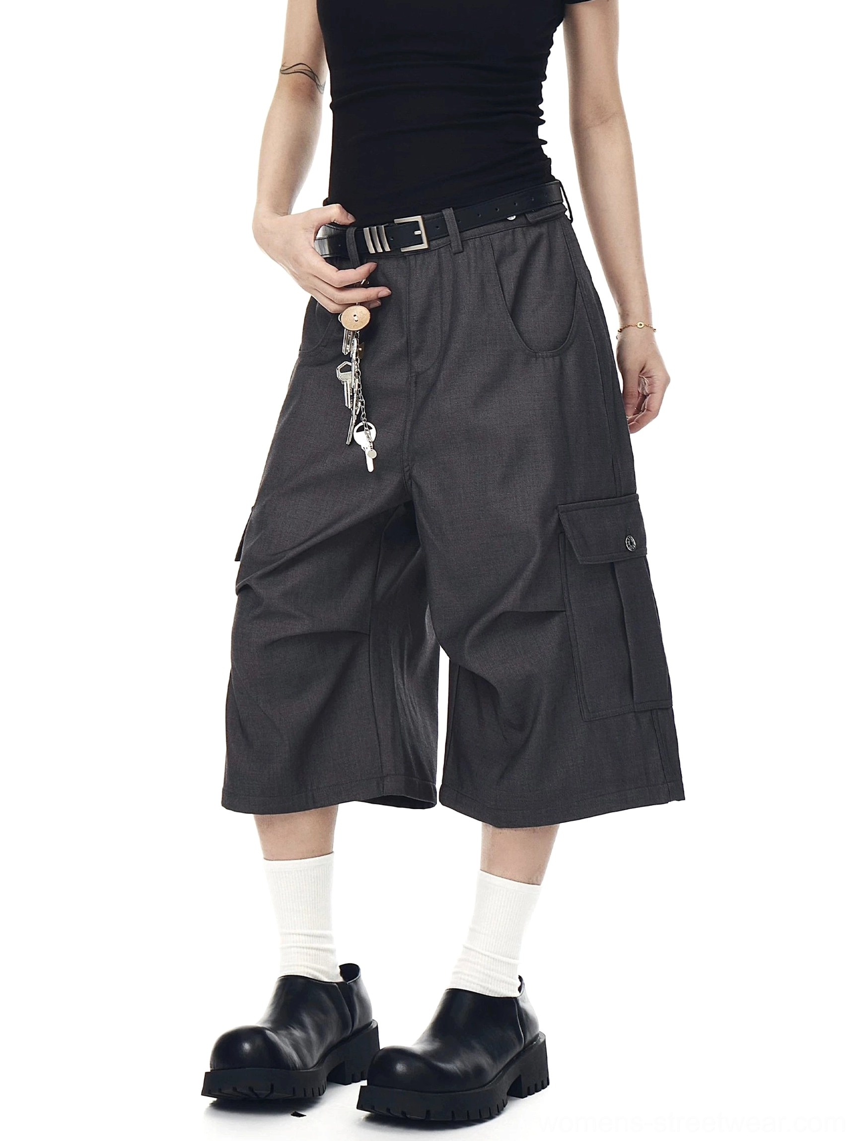 Front view of oversized dark gray cargo culotte shorts with wide cropped legs, side utility pockets, belt loops, and decorative keychain styling