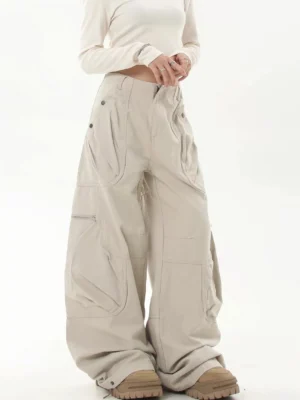 Apricot oversized utility cargo pants shown from a front three-quarter view with wide-leg streetwear fit, layered cargo pockets, and chunky tan boots