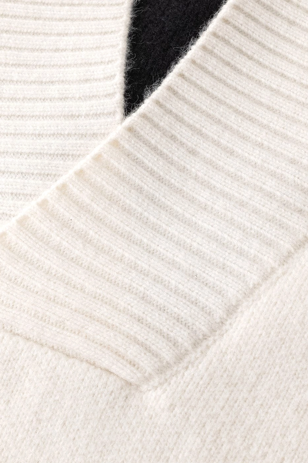 Detailed view of oversized V-neck racing stripe sweater knit texture and contrasting color block construction