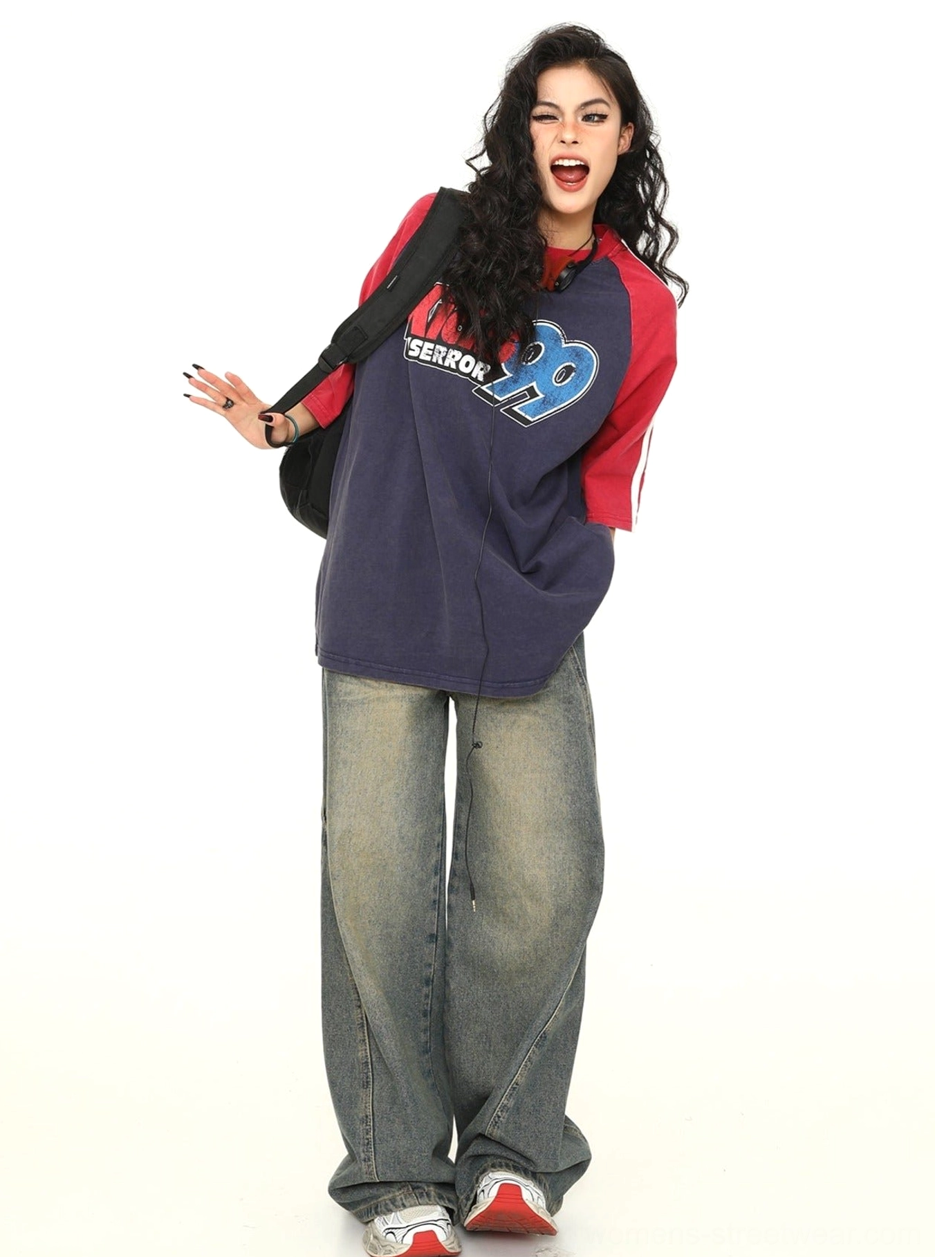 Three-quarter front view of an oversized varsity baseball raglan tee with contrast sleeves and retro number lettering