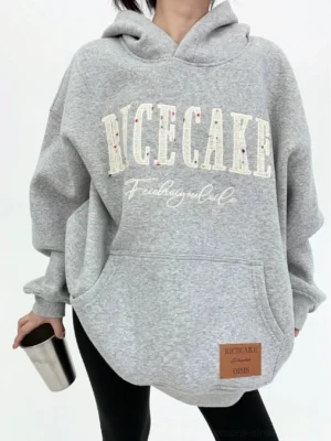 Heather gray oversized varsity graphic hoodie with heavyweight cotton fleece, kangaroo pocket, layered front lettering, and faux-leather hem patch