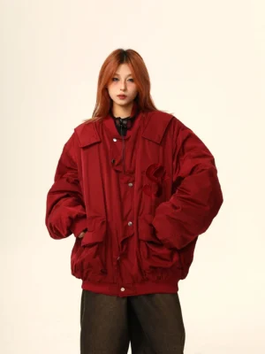 Burgundy oversized Varsity S bomber jacket shown from the front with snap buttons, embroidered chest detail, ribbed trims, and relaxed Korean streetwear styling