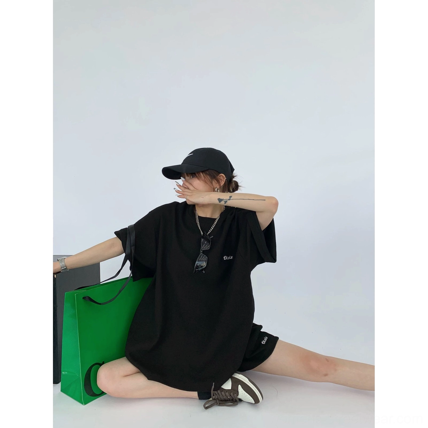 Black oversized waffle knit T-shirt and shorts matching set styled with a crossbody bag