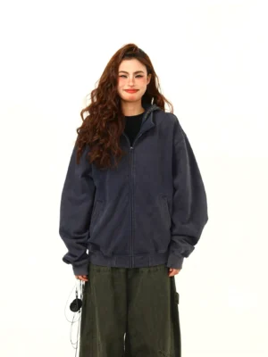 Front view of an oversized washed navy hooded zip jacket with drop shoulders and side pockets for women's streetwear