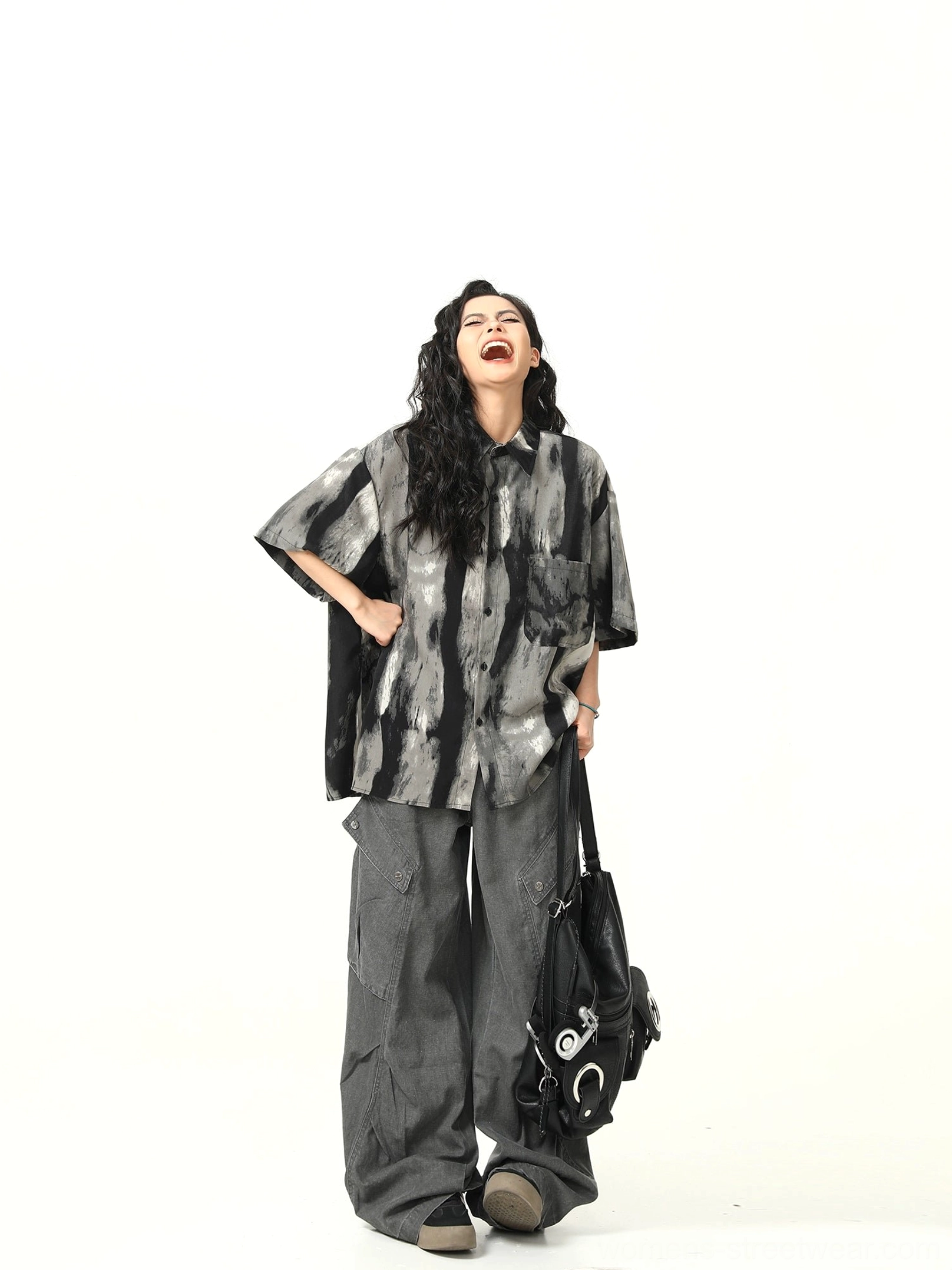 Side view of oversized black gray watercolor streetwear shirt styled with wide-leg gray cargo pants and black tote
