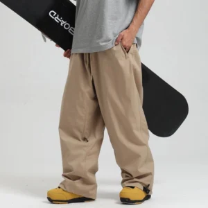 Khaki oversized waterproof snow pants with wide leg streetwear snowboard fit worn with yellow ski boots