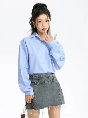 Sky blue oversized streetwear button-down shirt styled with a frayed denim mini skirt