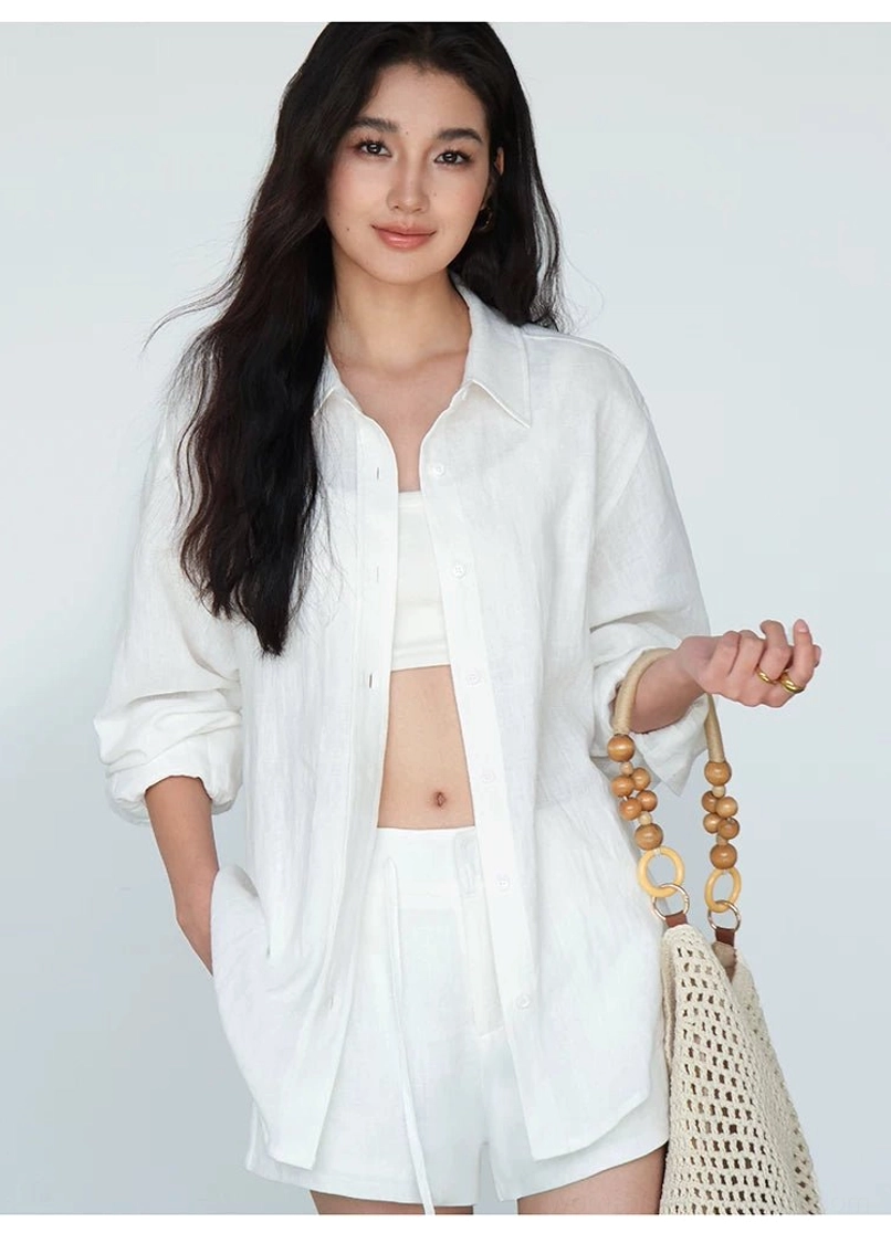 Oversized white ramie linen shirt worn open over fitted base layer contemporary streetwear silhouette