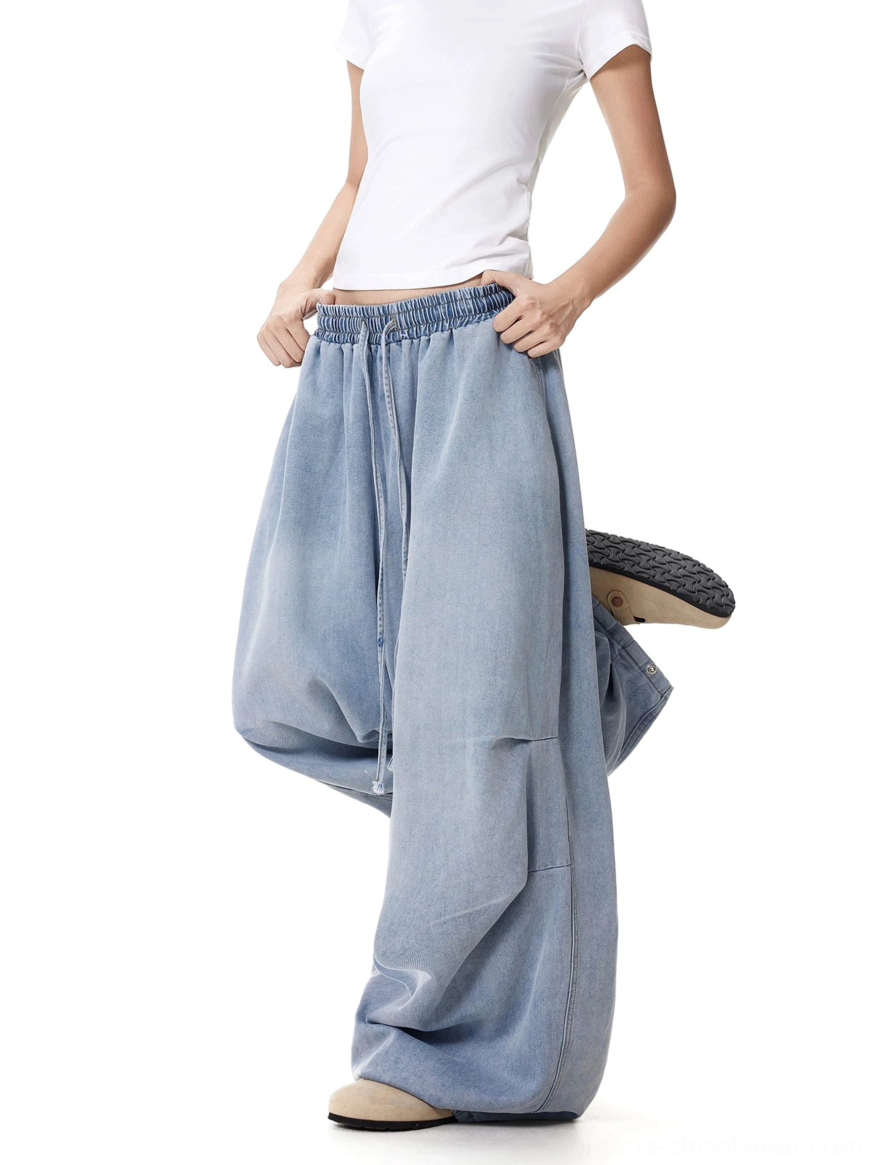 Women's oversized wide-leg drawstring jeans shown in motion with loose fabric drape, functional pocket, adjustable waist, and casual streetwear styling