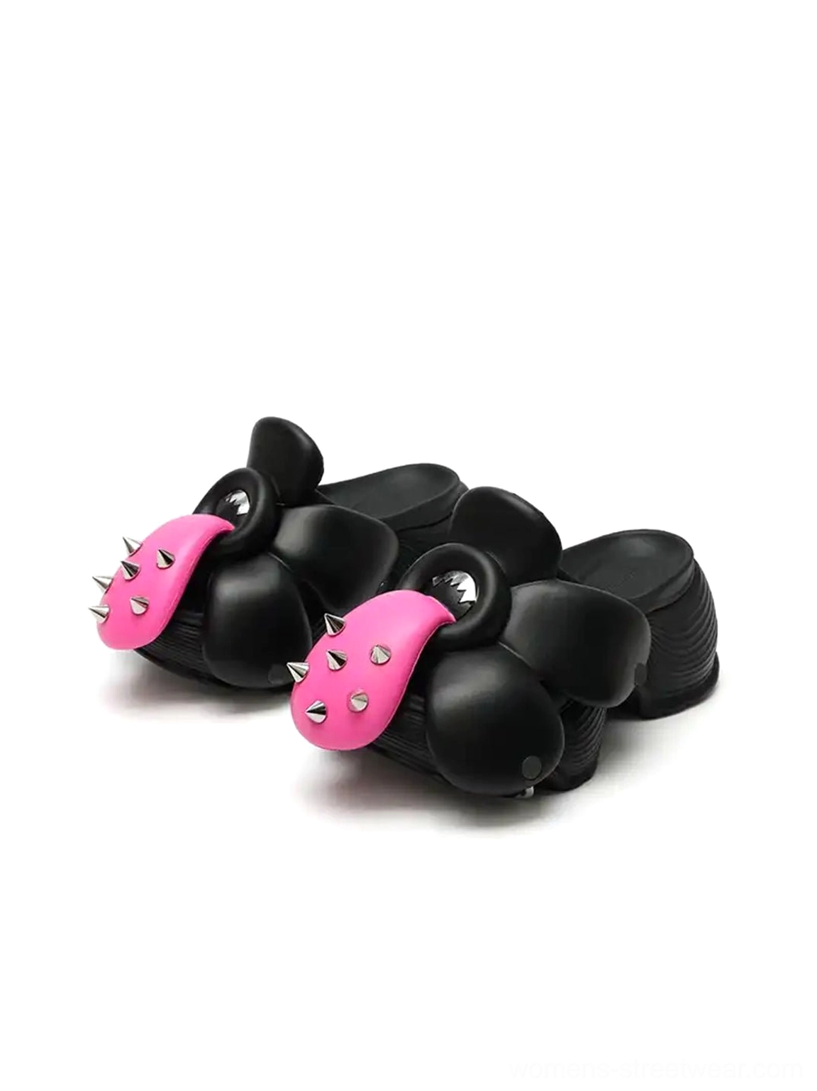 Three quarter product view of paired black sculpted flower platform slip-on shoes showing the thick elevated sole and dimensional upper