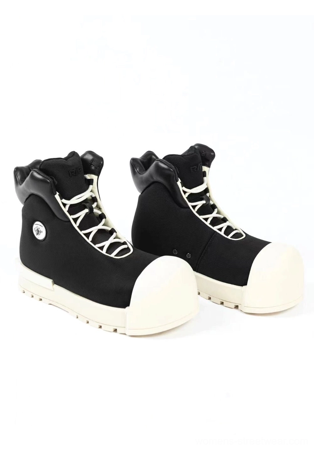 Pair of black sculpted-toe platform high-top boots displayed side by side with visible white laces, off-white toe caps, thick soles, and round side badges