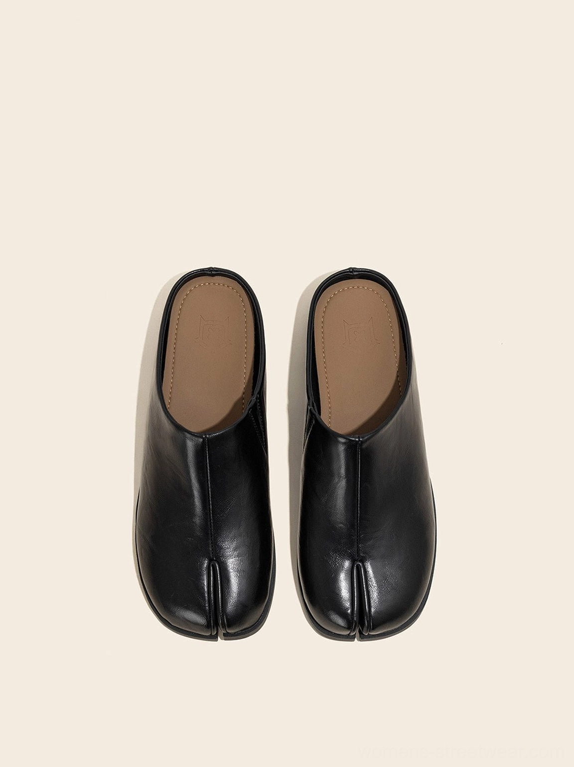 Pair of black split-toe leather backless flat mules showing the squared toe and contrasting inner insole