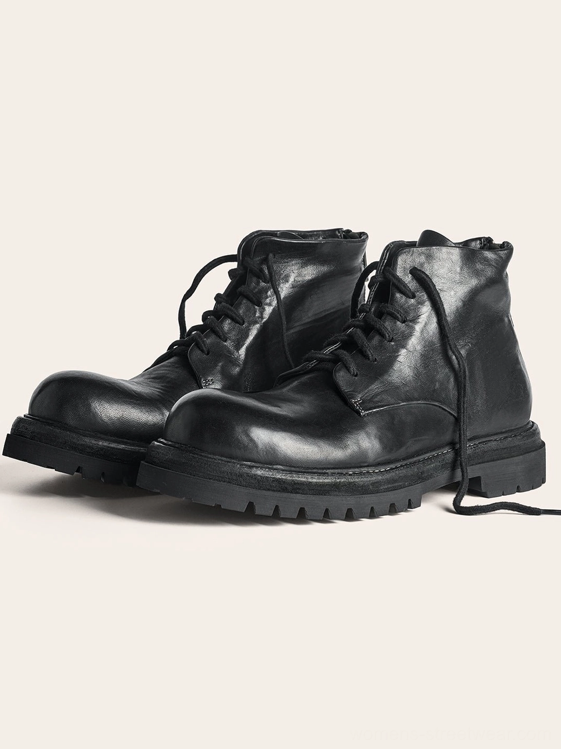 Pair of black vintage combat boots shown in a side three-quarter view with loose laces, washed horsehide leather, and thick chunky outsoles