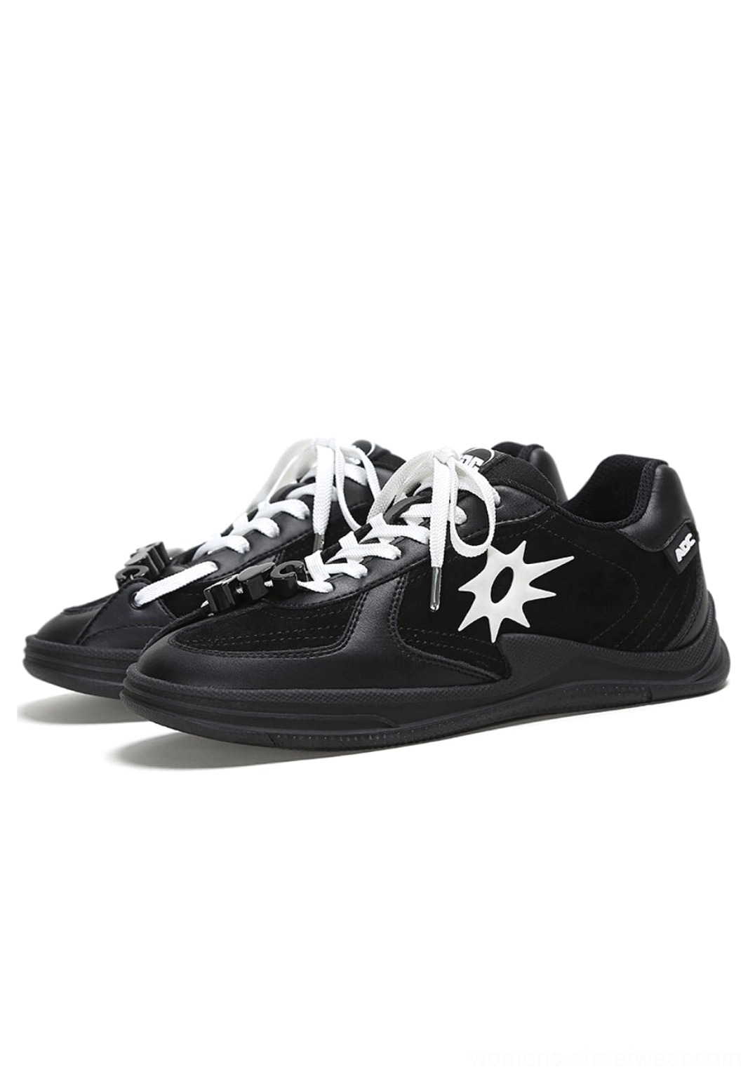 Pair of black and white leather court sneakers with solar star appliques displayed in a front three-quarter studio view