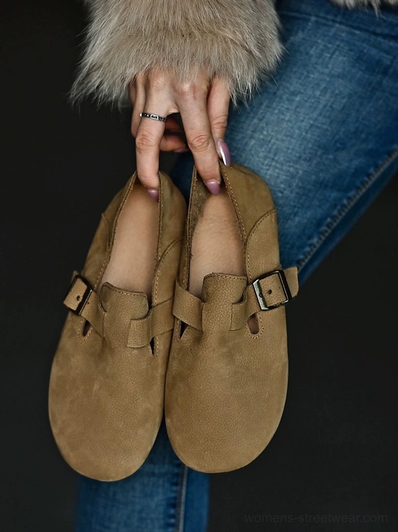 Pair of tan leather buckle loafers held together, displaying the rounded toe shape, adjustable straps, and matching neutral color