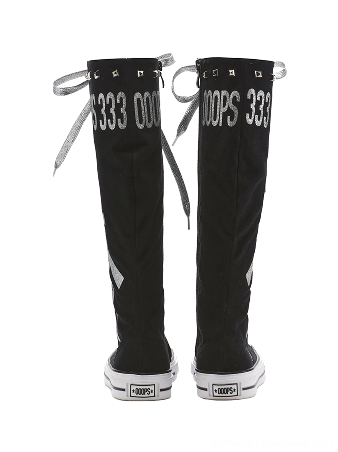 Rear view of paired black graphic canvas knee-high boots showing printed rear lettering, tied silver laces, tall shafts, and white rubber soles
