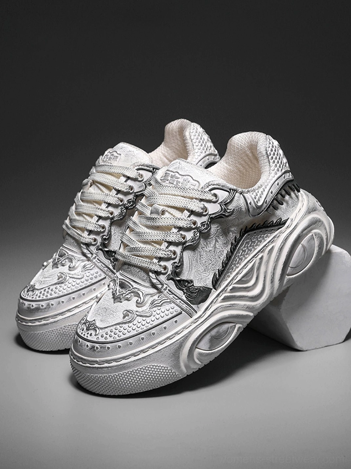 Pair of white distressed chunky platform sneakers with bone-inspired upper decorations and prominent wave-molded soles