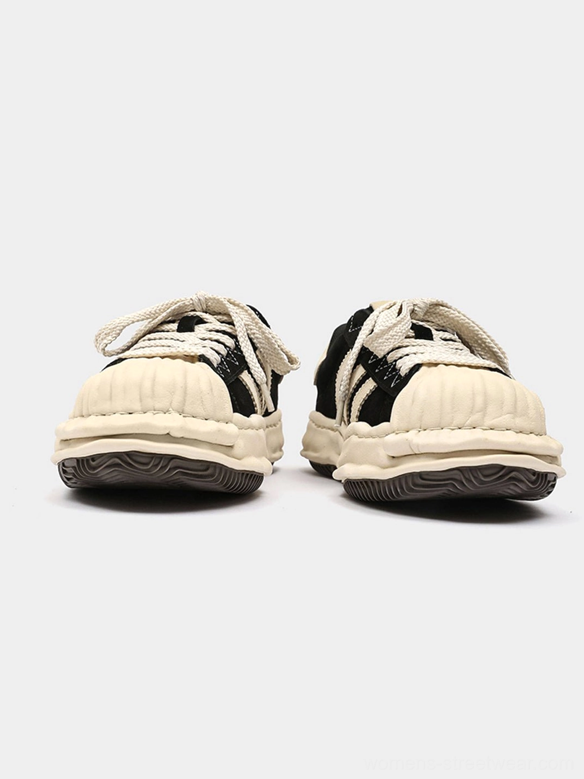Paired black and off-white melted shell-toe platform sneakers displayed from above with chunky aged-style soles and retro streetwear details