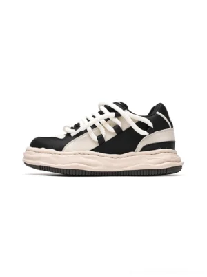 Black and white paneled wavy platform sneakers shown in a side-front product view with chunky round laces, contrast color blocking, and thick sculptural soles