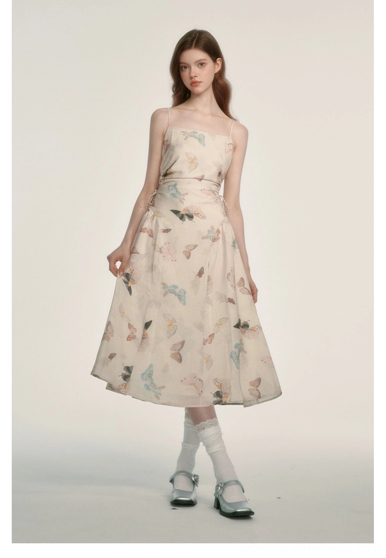Three-quarter view of a pastel butterfly print cream midi dress with square neck and fitted spaghetti strap silhouette