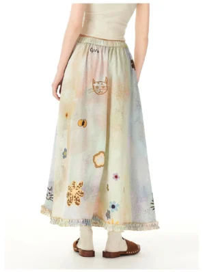 Rear view of a pastel cat garden maxi skirt with watercolor gradient print, floral kitty illustrations, elastic high waist, and ruffled hem