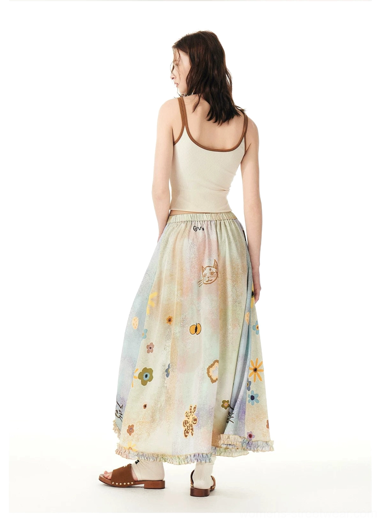 Side rear view of a flowy pastel cat garden maxi skirt styled with a beige cropped camisole and relaxed A-line silhouette