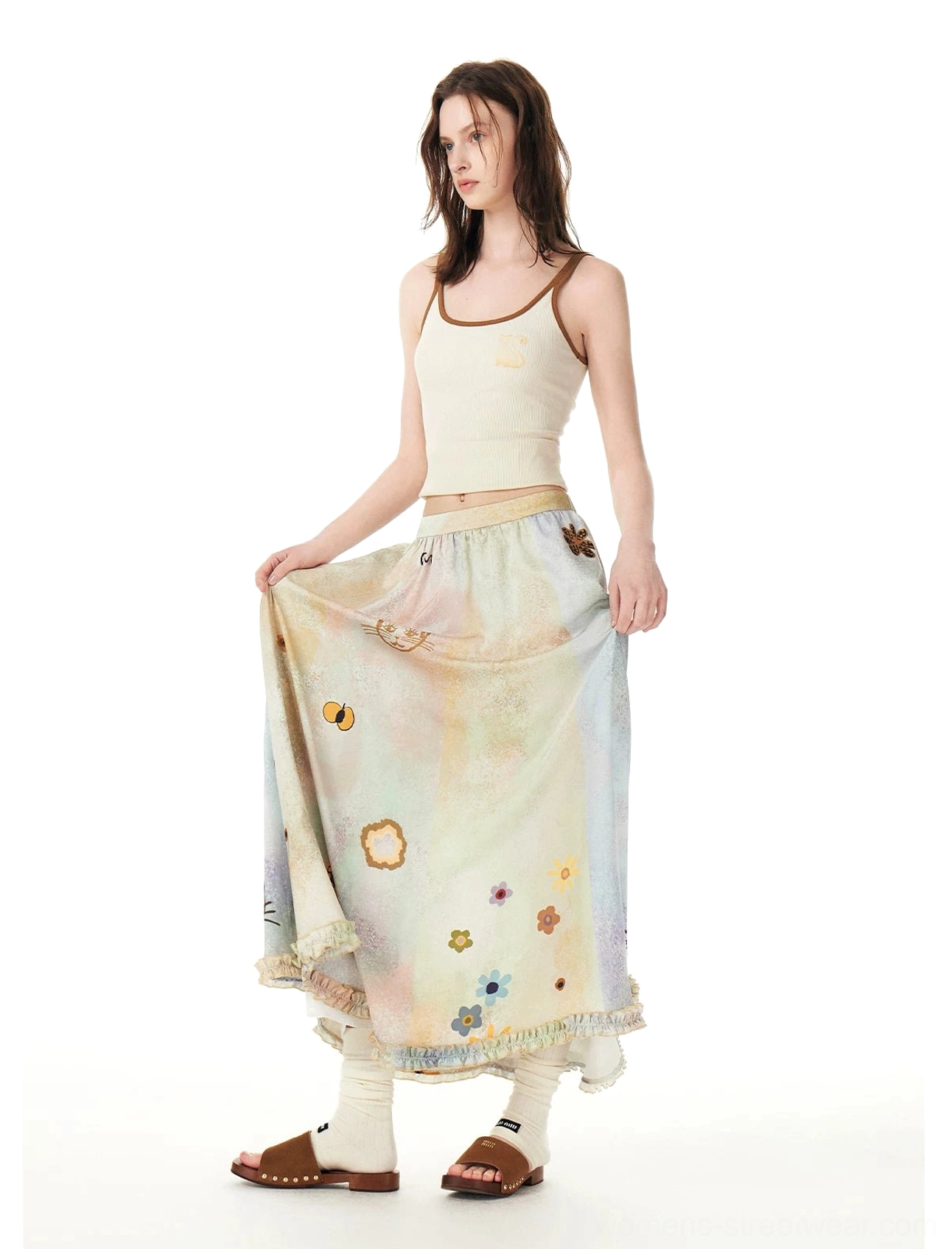 Front three-quarter view of a pastel cat print A-line maxi skirt with playful garden illustrations, high elastic waist, and ruffled hem