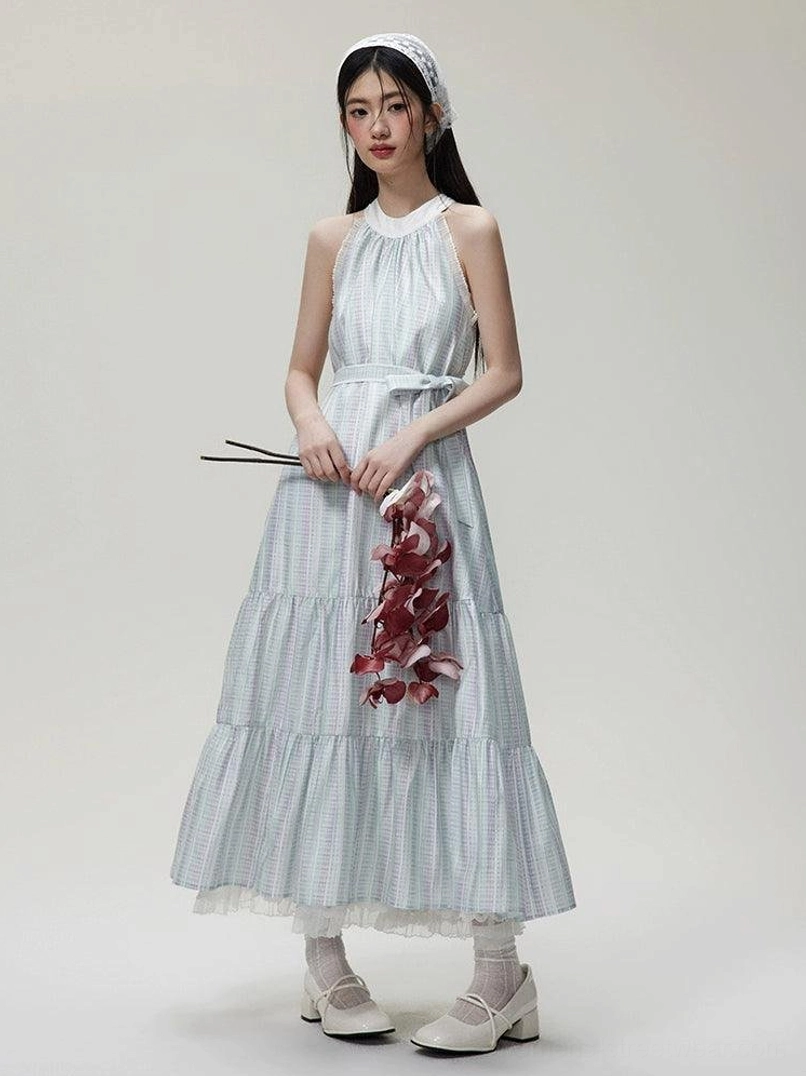 Full front view of a pastel checkered halter maxi dress with matching waist sash, ruffled organza tiers, lace hem, and floral styling