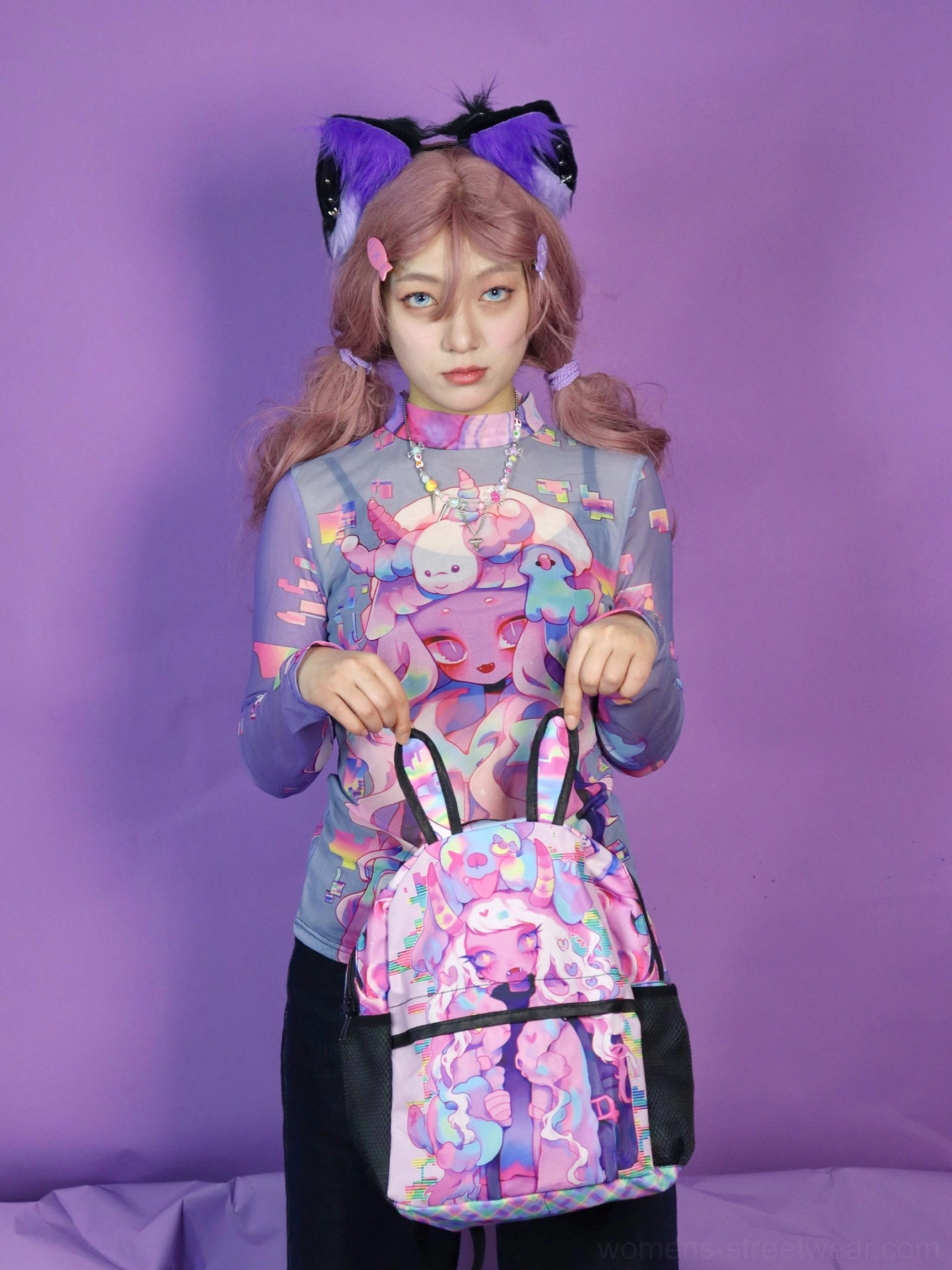 Y2K pastel mesh long sleeve cartoon print top styled with black trousers and a matching graphic backpack