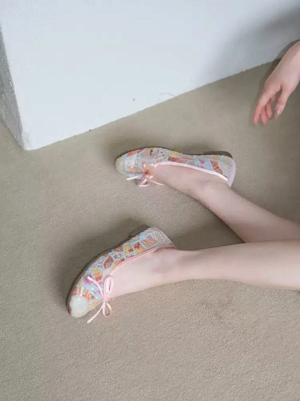 Close top view of pastel floral mesh ballet flats on feet showing pink bow lacing and breathable sheer floral upper