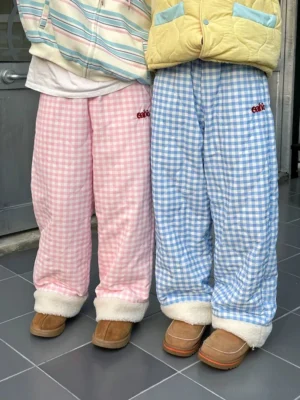 Pastel pink and blue gingham fleece cuff streetwear pants displayed indoors with plush rolled hems and relaxed straight-leg fit