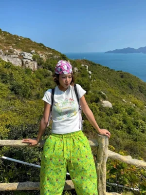 Pastel meadow floral fitted baby tee styled with lime green floral wide-leg pants on a coastal hiking trail