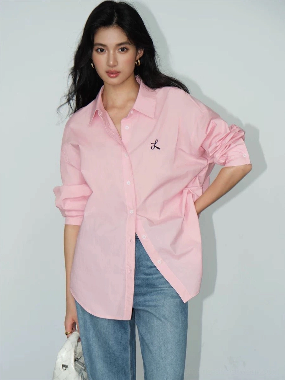 Pastel pink embroidered oversized button-down shirt with classic collar styled with wide-leg blue jeans