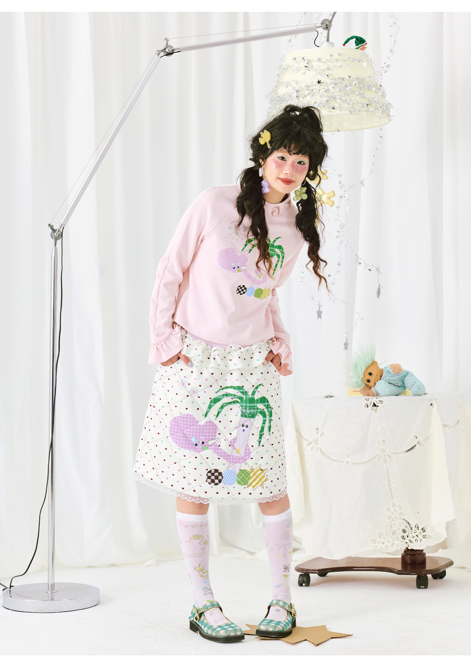 Right side view of a pastel pink printed ruffle cuff top showing its relaxed silhouette and feminine streetwear styling