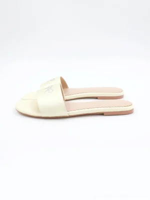 Cream pastel rhinestone bow square-toe flat slide sandals shown in a top-down product flat lay on a white background