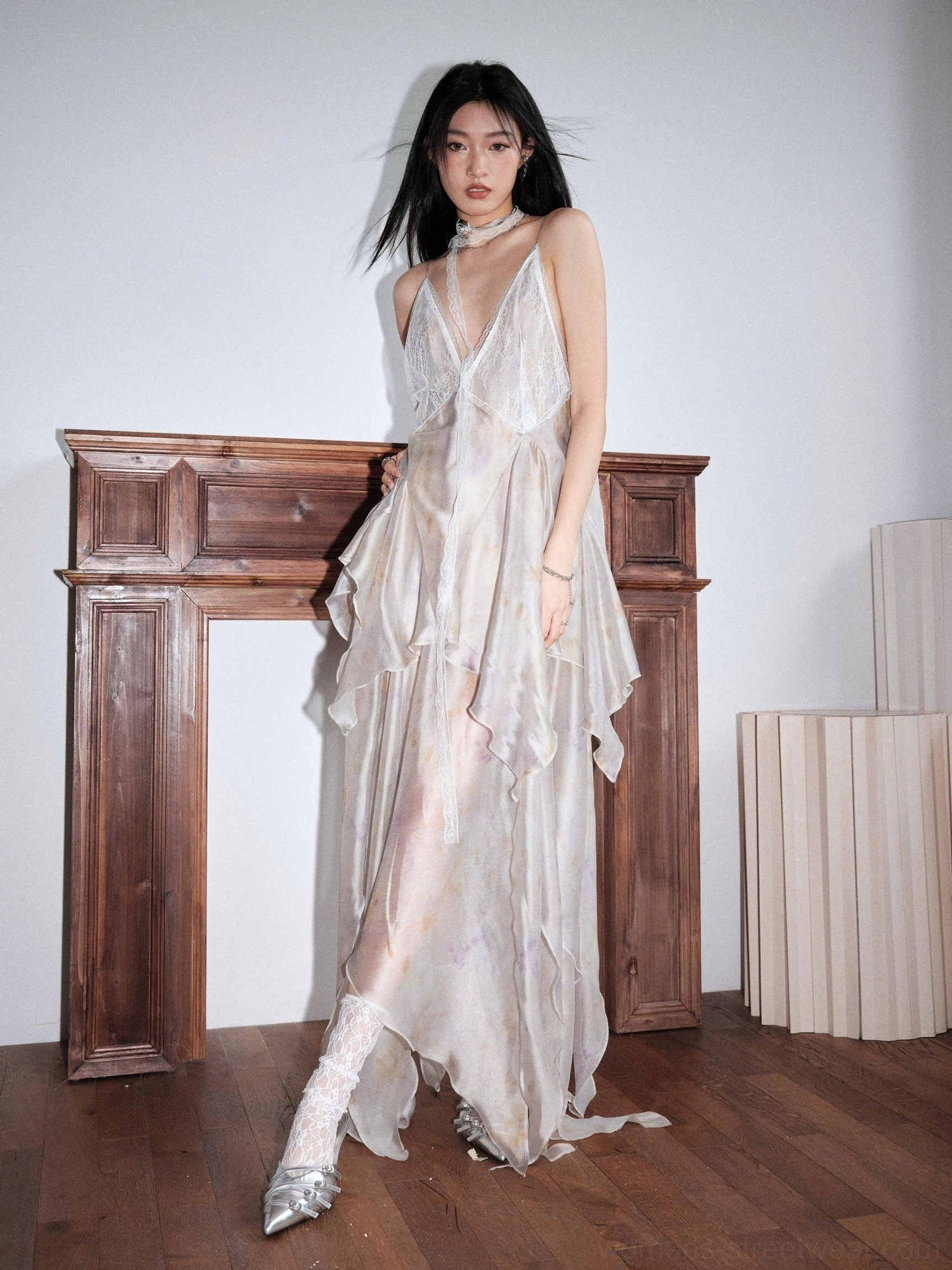 Pastel tie dye chiffon maxi dress shown in a side three-quarter view with open back, airy sheer layers, flowing fabric, and uneven floor-length hem