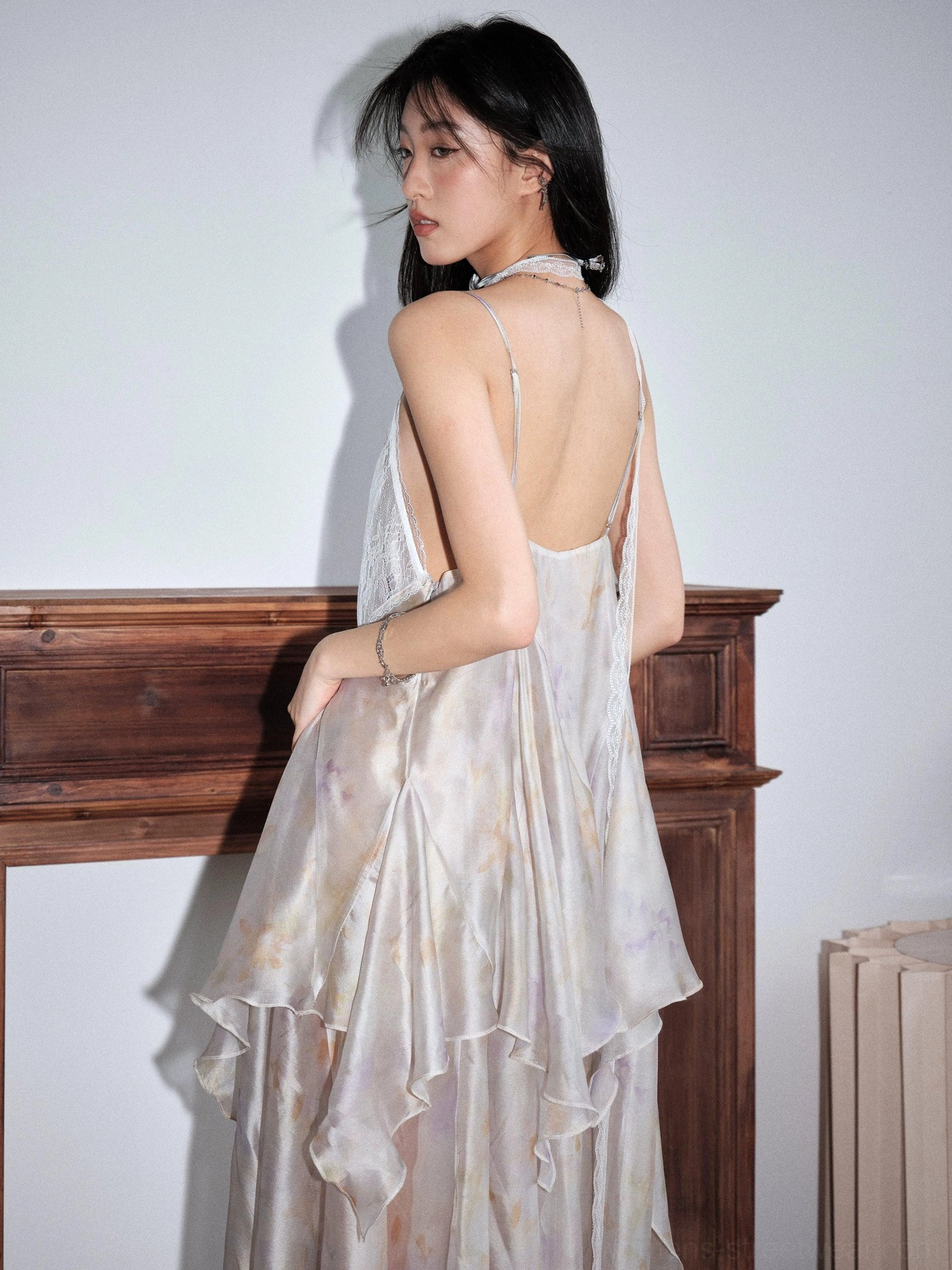 Pastel tie dye chiffon slip dress with asymmetric layered ruffles, deep V neckline, open back, high side slit, and flowing maxi silhouette