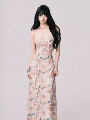 Front full body view of a pastel watercolor floral cami maxi dress with ruched bust, fitted waist, slim spaghetti straps, and flowing ankle length skirt