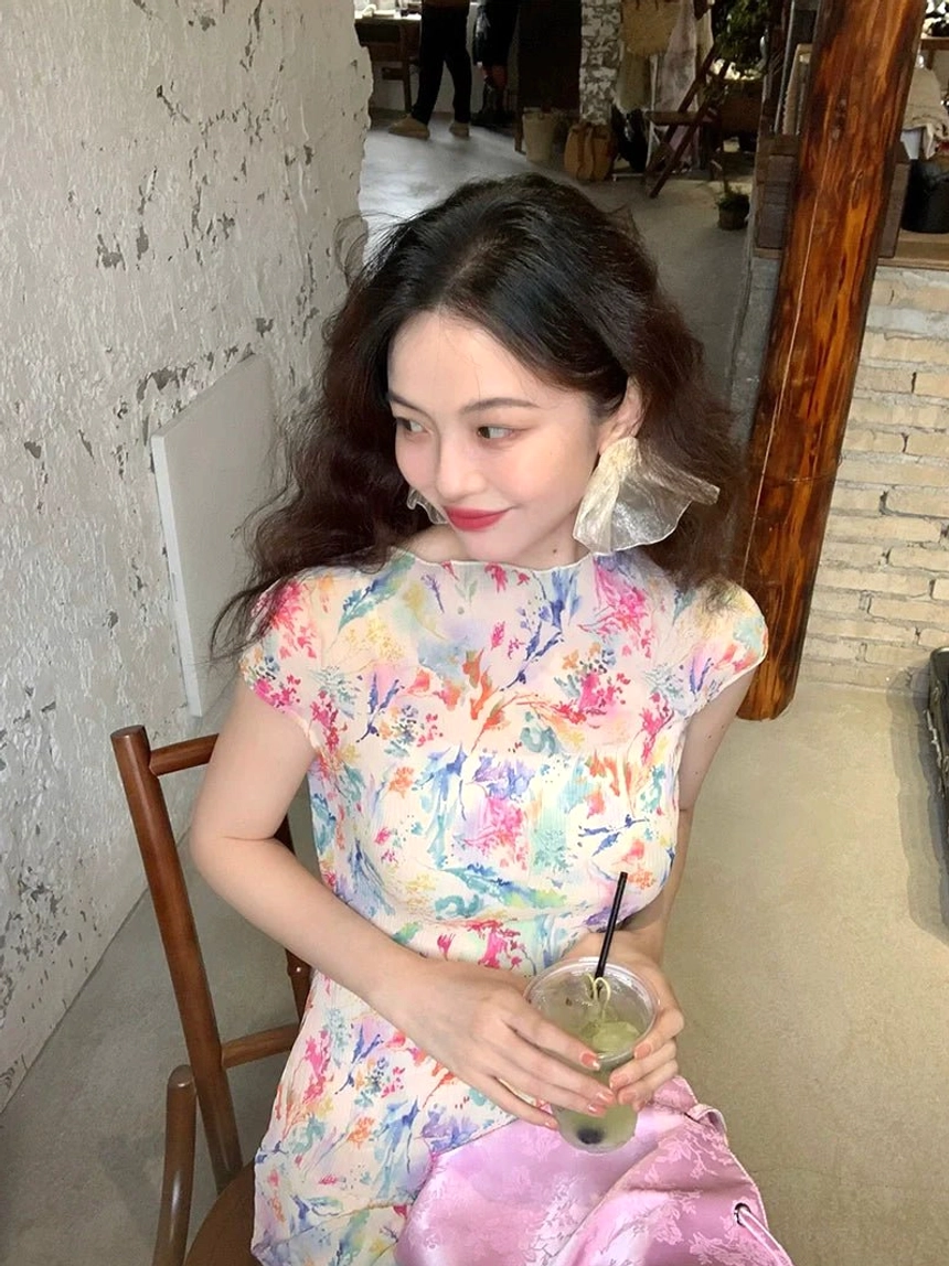 Close-up of pastel watercolor floral cheongsam-inspired maxi dress styled with sheer flower earrings and pink bag