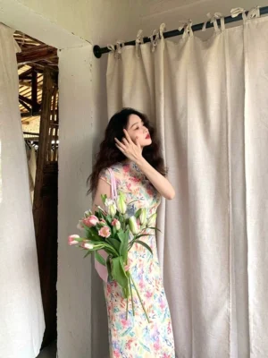 Side back view of pastel watercolor floral cheongsam-inspired maxi dress showing ankle-length fitted profile