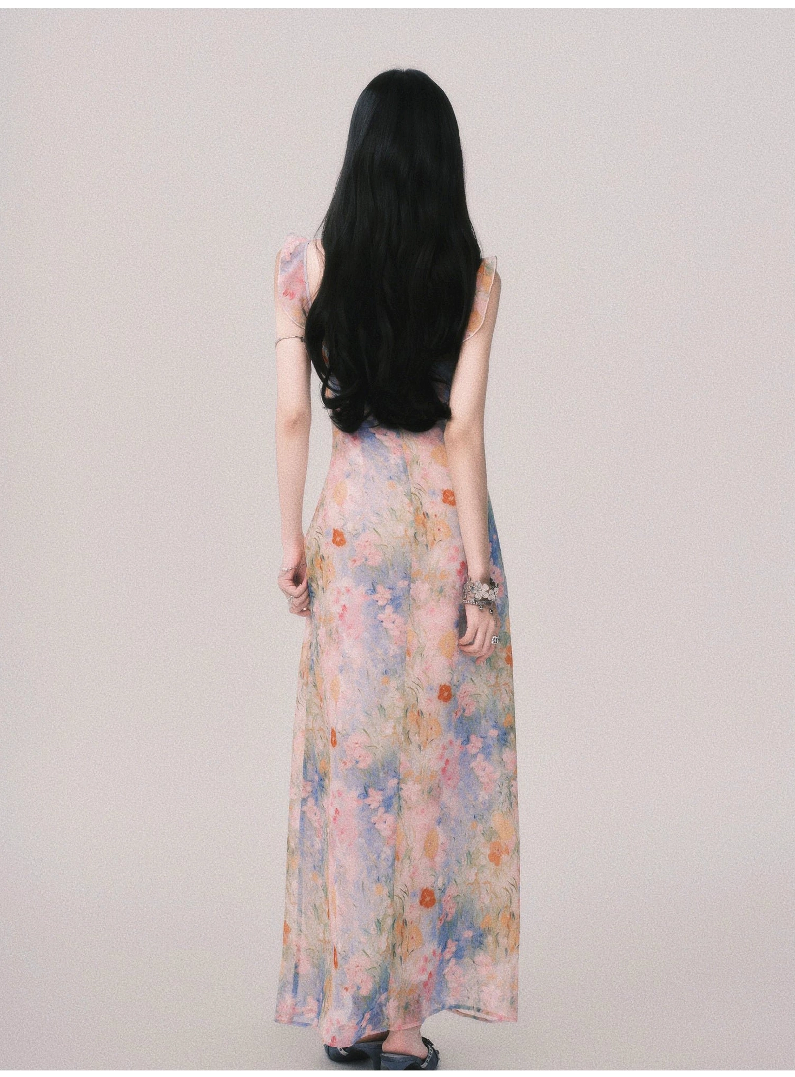 Back view of pastel watercolor floral maxi slip dress with thin shoulder straps and airy open-back styling